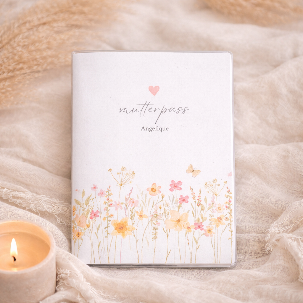 Personalisierte Mutterpass Hülle mit zarter Wiesenblumen Aquarell Illustration im Boho Stil, individuell mit Namen personalisiert, fotografiert auf beigem Stoffhintergrund.