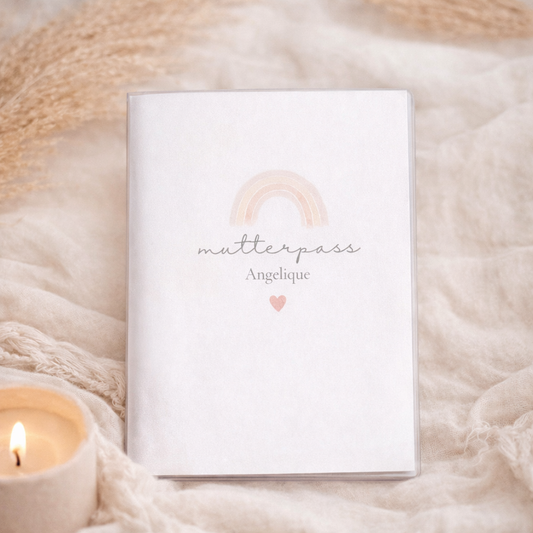 Personalisierte Mutterpass Hülle mit zartem Pastell Regenbogen im Boho Stil in soften Naturtönen, individuell mit Namen personalisiert, fotografiert auf beigem Stoffhintergrund.