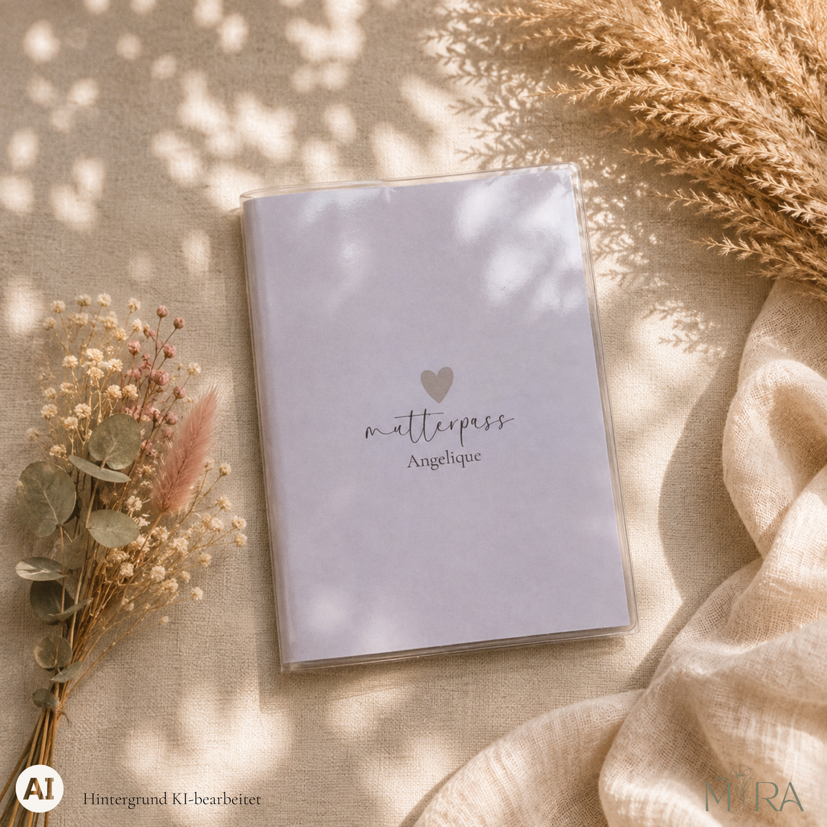 Personalisierte, schlichte Mutterpasshülle „Clara" mit kleinem Herz und Schriftzug „mutterpass Angelique" auf hellem Untergrund – ma e mira