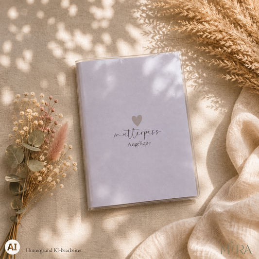 Personalisierte, schlichte Mutterpasshülle „Clara" mit kleinem Herz und Schriftzug „mutterpass Angelique" auf hellem Untergrund – ma e mira